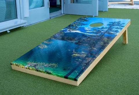 Cornhole platform with nature theme sitting on turf Stock Photos