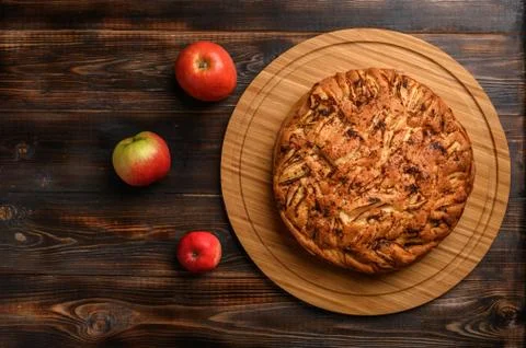 Cornish apple pie top view on rustic style brown background. Next to three Stock Photos