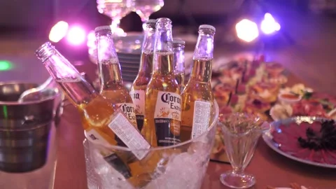 Corona Extra beer in glass bottles in a container with ice at a party Stock Footage 301404286