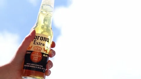 Corona Extra beer in a woman's hand against the sky Stock Footage 308954825