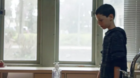 Corona pandemic - Boy using hand sanitizer to prevent coronavirus spread Stock Footage 126609625