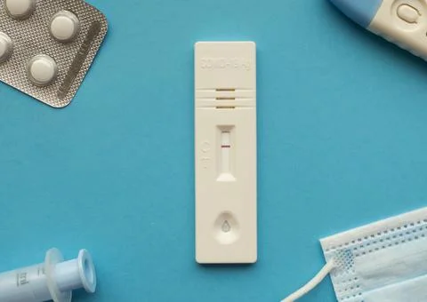 Coronavirus antigen test with a negative result on a blue bright background next Stock Photos