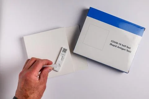 Coronavirus lateral flow self test kit on white background with male hand Stock Photos