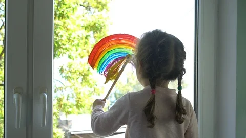 Coronavirus lockdown: A child drawing rainbow pictures on their windows Stock Footage 129531394
