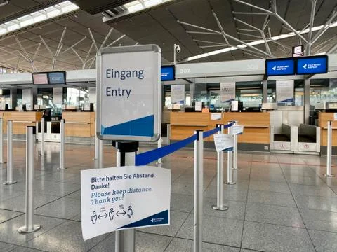 Coronavirus outbreak: Empty check-in desks with Corona safety reminders at the Stock Photos