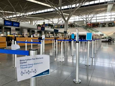 Coronavirus outbreak: Empty check-in desks with Corona safety reminders at the Stock Photos