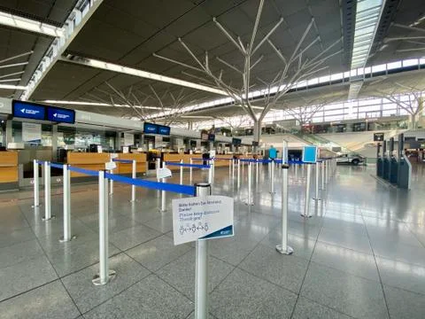 Coronavirus outbreak: Empty check-in desks with Corona safety reminders at the Stock Photos