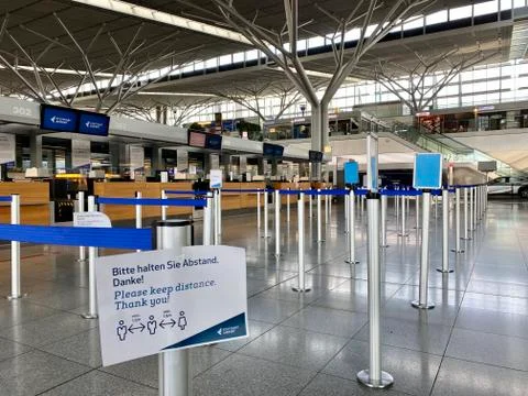 Coronavirus outbreak: Empty check-in desks with Corona safety reminders at the Stock Photos