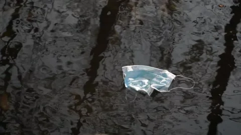 Coronavirus outbreak - garbage, disposable masks in water, river, lake Stock Footage 142453239