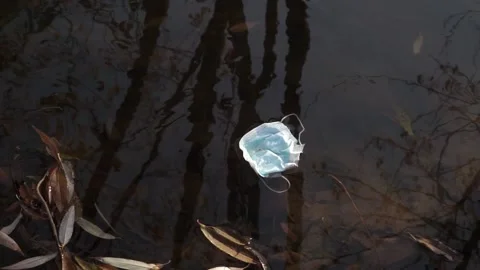 Coronavirus outbreak - garbage, disposable masks in water, river, lake Stock Footage 142454061