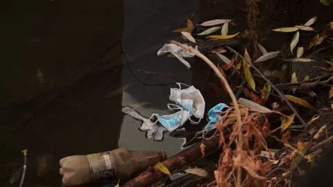 Coronavirus outbreak - garbage, disposable masks in water, river, lake Stock Footage 142454594