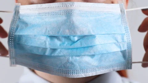Coronavirus pandemic, covid 19. Close up of woman putting on a medical mask Stock Footage