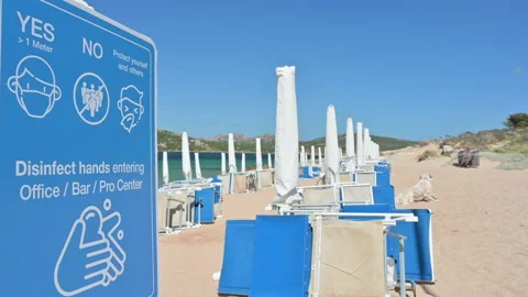 Coronavirus protective measures sign on empty beach Stock Footage 132830241