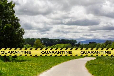 Coronavirus quarantine warning tape with empty park on the background. Covid- Stock Photos