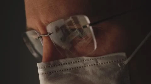 CORONAVIRUS: Reflection at the glasses. Man put on a mask Stock Photos