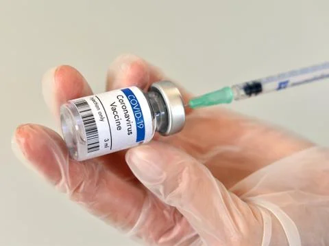 Coronavirus vaccine vial, bottle, phial, ampule in hand in research laboratory Stock Photos