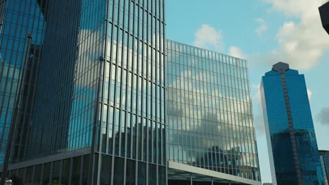 Corporate buildings reflecting cloudscape on mirror facades in urban environment Stock Footage 305273674