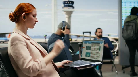 Corporate executive checking reports and analytics on laptop in airport terminal Stock Footage 339643033