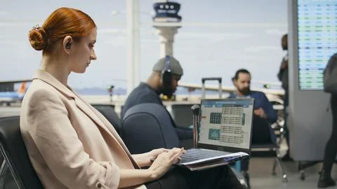 Corporate executive checking reports and analytics on laptop in airport terminal Stock Photos