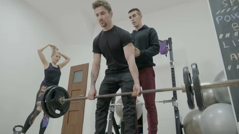 Corporate man in his first day at the gym lifting dumbbells and working out h Video stock 87202786