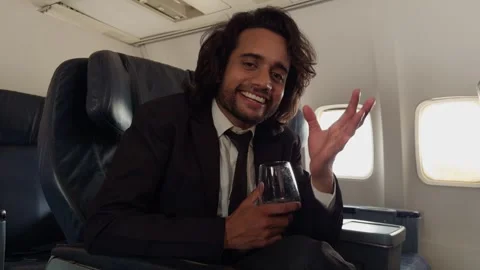 Corporate man in suit laughs while chatting mid flight Stock Footage 314179176