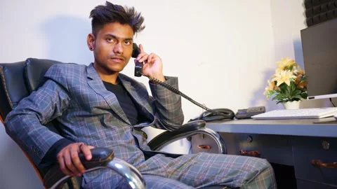 Corporate man talks on landlines while sitting in office Stock Footage 302635992