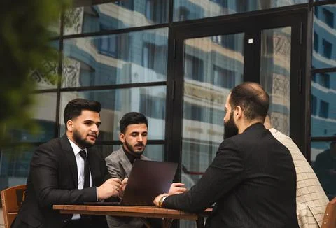 Corporate meeting of business partners outside the office. Male employees sit at Stock Photos