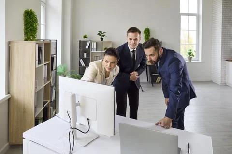 Corporate team discussing strategy at computer in bright office, analyzing data Stock Photos