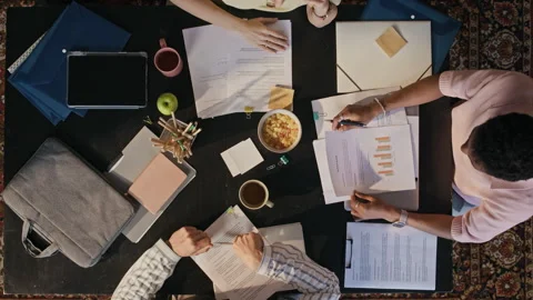 Corporate Team Stacking Hands while Analyzing Reports during Office Meeting Stock Footage 342060859