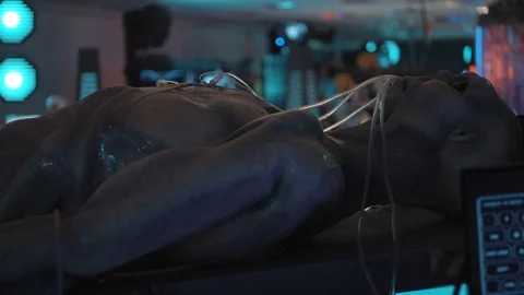 Corps of humanoid is lying on table in medical room of alien cosmic ship Stock Footage 101360014