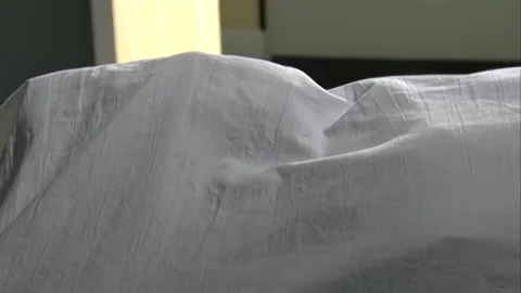 Corpse covered with white cloth Stock Footage 253771334