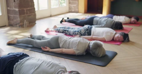 Corpse pose, relax and people in yoga class rest on mat in meditation for Stock Footage 307882299