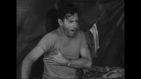 Corpsmen gets up to check the status outside the tent - 1954 Stock Footage 102824854