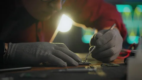 To correct. An engineer uses professional skills to repair a phone in an ele Stock Footage 278190170