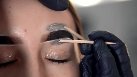 Correction of a shape of eyebrows with hot wax Stockbeeldmateriaal 146531638