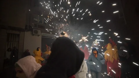 Correfoc devil running through a crowd with fireworks in hand Stock Footage 100376135