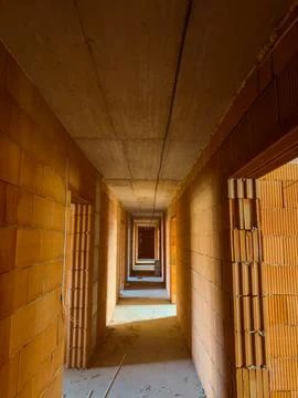 A corridor at a construction site features walls made of bricks with open doo Stock Photos