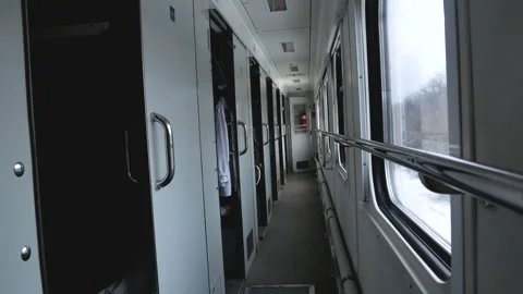 Corridor of a moving train. The compartment doors are ajar in the carriage Stock Footage 264104186