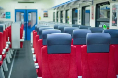 Corridor with rows of seats with headrests in modern suburb commuter train Stock Photos
