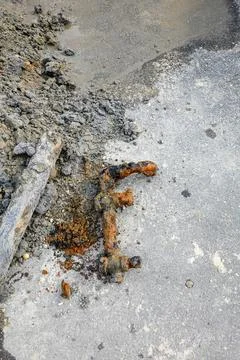Corroded portion of pipe valve laying on the ground after it was replaced d.. Stock Photos