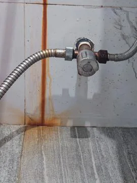 Corroded Water Pipe with Rust Leakage Stain on Wall Showing Plumbing Damage Stockfoto's
