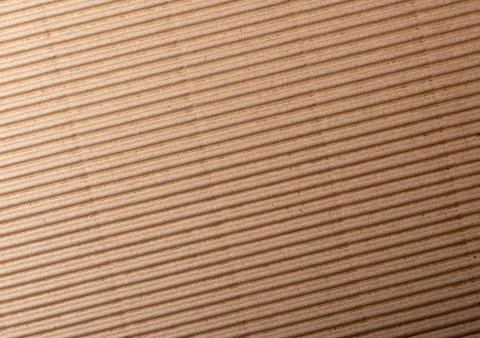 Corrugated cardboard surface texture close-up with parallel diagonal ridges. Stock Photos