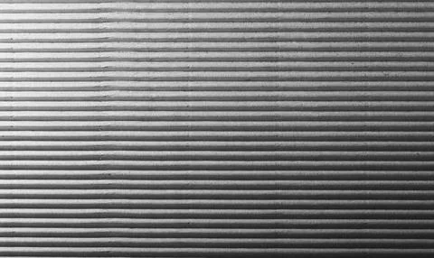 Corrugated cardboard surface texture close-up with parallel diagonal ridges. Stock Photos