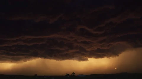 Corrugated murky storm cloud hanging over a prairie farm at sunset, time lapse Vídeo Stock 59525774