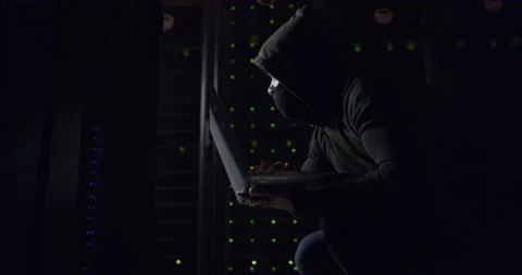 Corrupting systems while hiding in the shadows. 4k video footage of a hacker Video stock 201054909