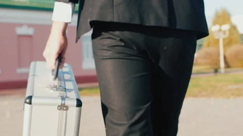 Corruption and bribery concept. Man in black suit with silver case goes to Stock Footage 130627813