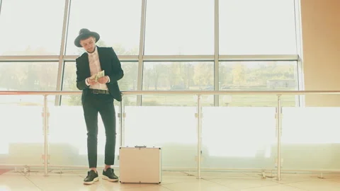 Corruption, bribery concept. Man in black suit and hat counts money dollars and Stock Footage 130790591