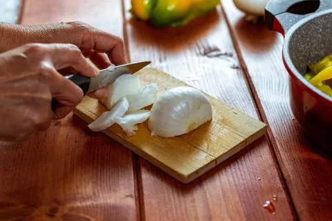 Cortando cebolla sobre tabla de madera con cuchillo de cocina Stock Photos