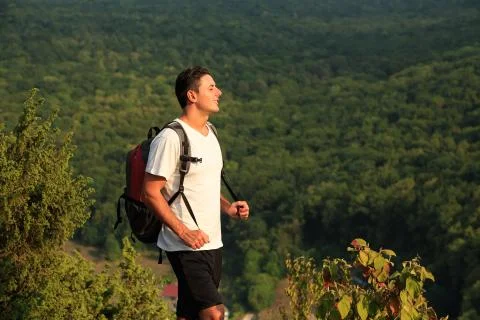 Cose up of smiling man with backpack on nature backgound Stock Photos