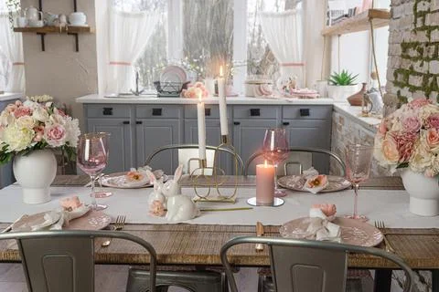 Coseup view on romantic cute table decor with glasses flowers and lit candles Stock Photos
